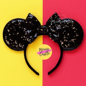 May include: Black and gold sequined Minnie Mouse ears headband with a black bow. The headband is on a yellow and red background. The text "Minnie Castle" is on a yellow circle.