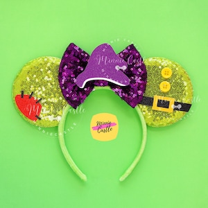 May include: Green and purple Minnie Mouse ears with a purple hat, yellow buttons, and a black belt. The ears are decorated with sequins and the hat has a bow. The headband is green.