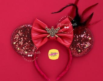 May include: Red Minnie Mouse ears with a red leather bow and a gold skull and crossbones charm. The ears are covered in red sequins and have a black feather accent.