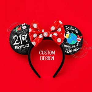 Op de afbeelding: Een zwarte haarband met twee ronde oren voorzien van lovertjes. Het linkeroor toont de tekst 21ST BIRTHDAY met een cocktailglas. Het rechteroor toont de tekst DRINKING AROUND THE WORLD met een bierpul en wijnglas. Een rode strik met stippen zit in het midden.