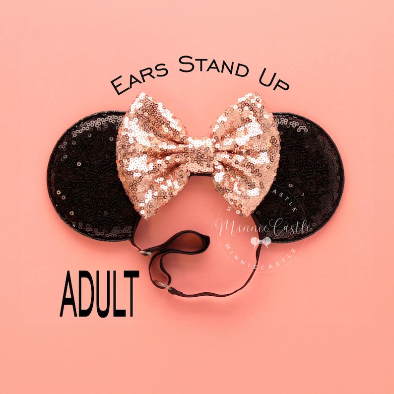 May include: Black and rose gold sequined Minnie Mouse ears with a black headband. The ears have the text "EARS STAND UP ADULT" printed on them.