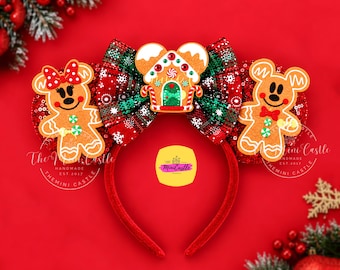 May include: A headband featuring two ears covered in red sequins, a central plaid bow, and gingerbread character appliques. The left ear has a gingerbread figure with a red bow, and the right has a gingerbread figure with a red bowtie. A gingerbread house sits in the center of the bow.