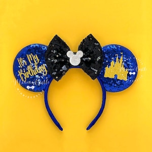 May include: Blue and black sequined Minnie Mouse ears with a gold castle and the text "It's My Birthday" in gold lettering.