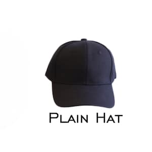 May include: A navy blue baseball cap with a curved peak. The cap features a rounded crown and a small button at the top. The text "PLAIN HAT" is printed in black below the cap.