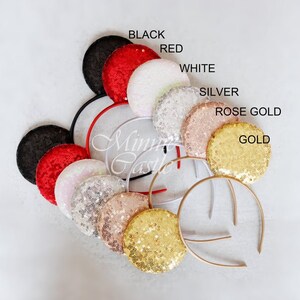 Puede incluir: Un conjunto de 10 pares de orejas de rat&oacute;n brillantes en varios colores, incluyendo negro, rojo, blanco, plateado, oro rosa y oro. Las orejas est&aacute;n unidas a una diadema.