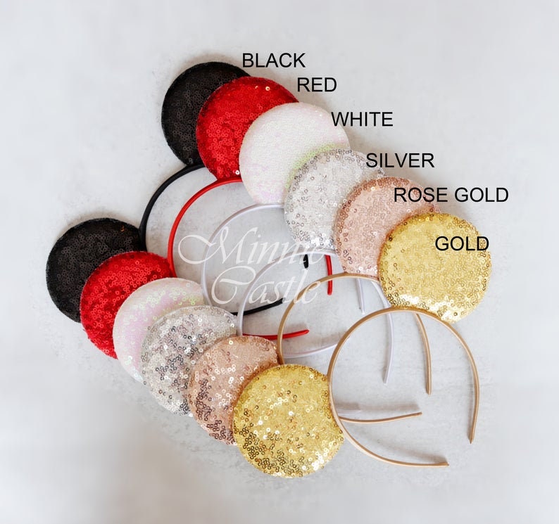 Puede incluir: Un conjunto de 10 pares de orejas de rat&oacute;n brillantes en varios colores, incluyendo negro, rojo, blanco, plateado, oro rosa y oro. Las orejas est&aacute;n unidas a una diadema.