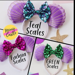 May include: Headbands with seashell-shaped ears in purple, gold, and white. Each headband features a bow with a scale pattern in teal, fuchsia, or green. The text on the headband reads "Teal Scales", "Fuchsia Scales", and "Green Scales".