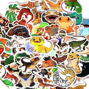 May include: A collection of colorful reptile and amphibian stickers, including lizards, geckos, and frogs, are arranged on a white background. The stickers feature various designs and colors, creating a vibrant and playful assortment.