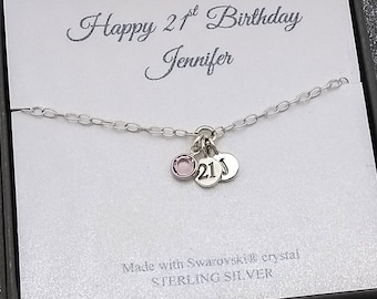 May include: A sterling silver necklace with a small pink crystal and two silver charms. One charm has the number "21" and the other has the letter "J". The card reads "Happy 21st Birthday Jennifer".