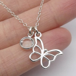 May include: A silver chain necklace with a delicate butterfly pendant and a clear round charm.