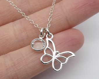 May include: A silver chain necklace with a delicate butterfly pendant and a clear round charm.
