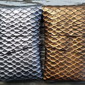 Op de afbeelding: Twee decoratieve zakjes met een schubbenpatroon. Het zakje links is zilver en het zakje rechts is goud.