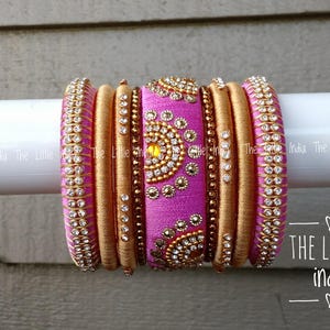 May include: A set of pink and gold bangles, adorned with beads and rhinestones. The bangles are displayed on a white surface. The image includes the text "THE LITTLE india".