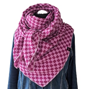 Könnte beinhalten: Ein rosa-weiß karierter Schal aus weichem, durchsichtigem Stoff. Der Schal ist gefaltet und um den Hals einer Person gelegt.