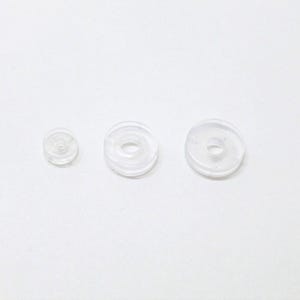 Op de afbeelding: Drie transparante plastic ringen in verschillende maten. De ringen zijn allemaal rond en hebben een gat in het midden.