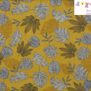 Könnte beinhalten: Ein gelber Stoff mit einem silbernen Blatt-Muster. Der Stoff ist mit einem sich wiederholenden Muster aus Blättern und Zweigen bedruckt. Der Stoff ist perfekt für Basteln, Quilten und andere Nähprojekte.