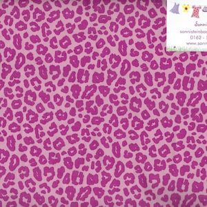 Könnte beinhalten: Rosa Stoff mit Leopardenmuster. Der Stoff hat einen hellrosa Hintergrund mit dunkleren rosa Leopardenflecken. Ein Lineal mit Zentimetermessungen ist am rechten Rand sichtbar.