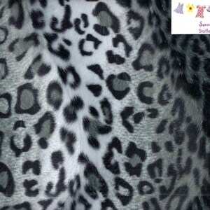 Könnte beinhalten: Nahaufnahme eines Stoffes mit Leopardenmuster. Das Muster zeigt schwarze und graue Flecken auf einem weißen und grauen Hintergrund. Der Stoff hat ein weiches, strukturiertes Aussehen, geeignet für verschiedene Nähprojekte.