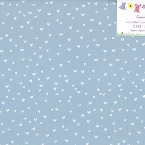 Könnte beinhalten: Hellblauer Stoff mit einem Muster aus kleinen weißen Herzen. Ein Lineal mit Zentimetereinteilung ist am rechten Rand sichtbar. Der Stoff hat eine weiche Textur, geeignet für Nähprojekte.