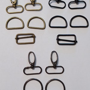 Könnte beinhalten: Sortiment an Metallbeschlägen in Gold-, Silber- und Schwarz-Finish.  Enthält D-Ringe, Drehverschlüsse und rechteckige Schnallen.