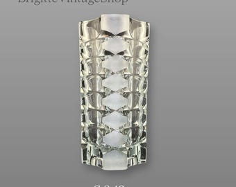 May include: A clear glass vase featuring a repeating geometric diamond pattern with frosted accents. The cylindrical vessel has a textured surface and a diameter of 9-12 cm. The text BrigitteVintageShop is visible at the top of the image.