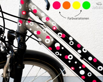 May include: A bicycle frame with a black and silver design featuring white and pink polka dots. The frame has a black and silver design with white and pink polka dots. The image also shows a color chart with four different colors: pink, orange, yellow, and green. The text "Farbvariationen" is written below the color chart.