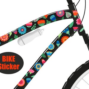 Puede incluir: Un cuadro de bicicleta negro con una pegatina de patrón floral colorido. La pegatina presenta una variedad de flores, hojas y formas geométricas en tonos de rojo, naranja, amarillo, verde, azul y morado. El texto "BIKE STICKER" está impreso en un círculo negro.