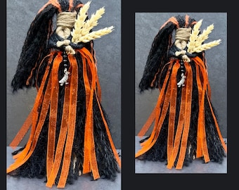 Op de afbeelding: Een handgemaakte Samhain Altar Poppet pop met zwarte en oranje accenten. De pop heeft lang zwart haar, oranje linten en een bundel tarwe. De tekst "Samhain Altar Poppet" en "Handcrafted by Gypsygold" zijn zichtbaar.