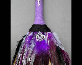 Puede incluir: Escoba de bruja morada y negra con plumas, cuentas y una llave y un amuleto plateados. Hecho a mano por Gypsygold.