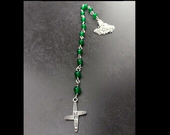 May include: Green beaded necklace with a silver Celtic cross charm. The necklace is labeled "Brigid Talisman" and "Handmade by Gypsygold".