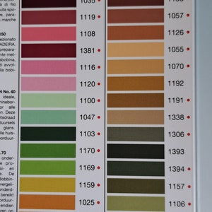 May include: A color chart for rayon thread with a variety of colors, including brown, orange, green, and black. The chart is labeled "Rayon" and includes numbers for each color. The chart is labeled "Madeira" at the bottom.