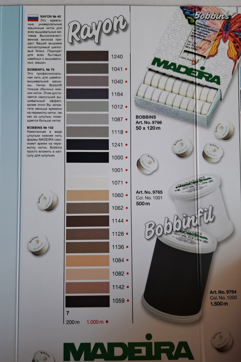 May include: A color chart of Madeira Rayon and Bobbinfil thread spools. The chart shows 15 different colors of thread, ranging from light beige to black. The spools are labeled with the thread number, color number, and length. The chart also includes the text "Rayon" and "Bobbinfil".