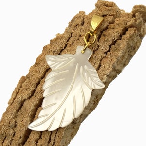 Könnte beinhalten: Ein weißer Perlmutt-Blatt-Anhänger mit einer goldfarbenen Öse.