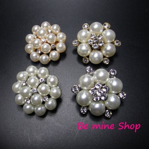 Könnte beinhalten: Vier Perlen- und Strass-Verzierungen in Blumenform. Jede Verzierung hat eine Mitte aus Strasssteinen und ist von weißen Perlen umgeben.