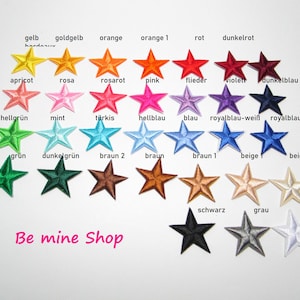 Könnte beinhalten: Sortiment von 24 Bügelbildern in Sternform. Jeder Stern hat eine andere Farbe, darunter Gelb, Orange, Rot, Pink, Blau, Grün, Braun und Weiß. Die Bügelbilder sind mit dem Farbnamen auf Deutsch beschriftet. Der Text "Be mine Shop" befindet sich am unteren Rand des Bildes.