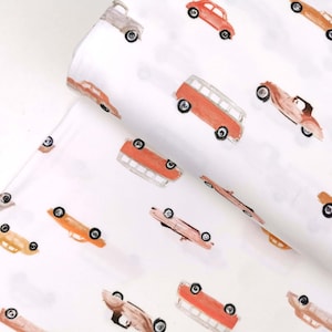 May include: White fabric with a repeating pattern of vintage cars and vans in shades of orange, red, and brown. The cars are all facing the same direction and have a whimsical, hand-painted look.