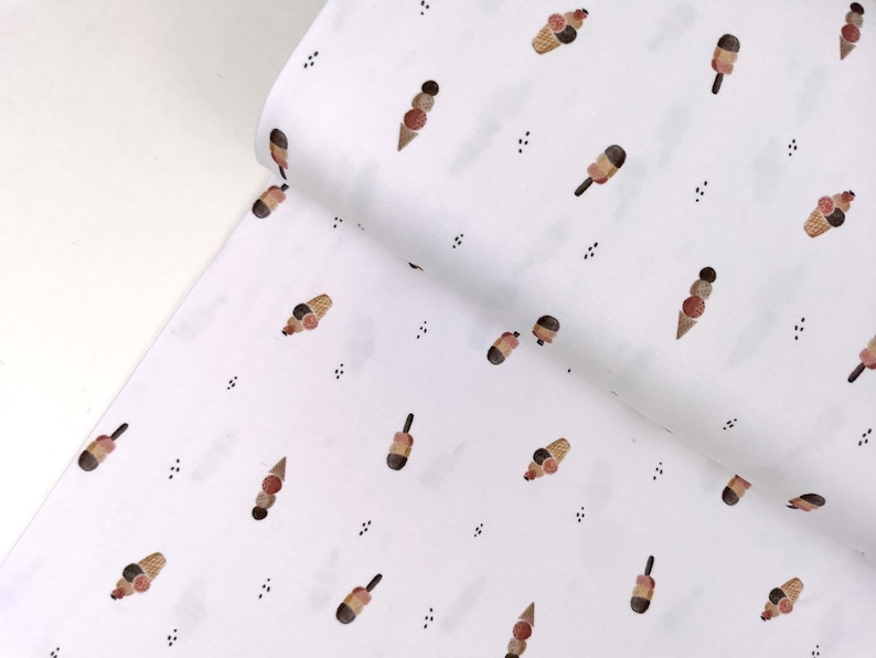 May include: White fabric with a repeating pattern of brown, pink, and white ice cream cones. The background is white with small black dots.