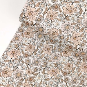 May include: A white fabric with a brown and pink floral pattern. The fabric is covered in small and large flowers.