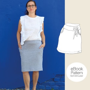 Puede incluir: Una mujer con una blusa blanca y una falda gris se encuentra frente a una pared azul. A la derecha de la imagen se muestra un dibujo lineal de una falda con cintura de cordón. El texto "eBook Pattern Schnittmuster" está en la parte inferior de la imagen.