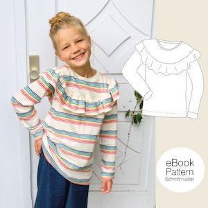 Könnte beinhalten: Ein Mädchen trägt ein gestreiftes Langarmshirt mit Rüschenkragen. Das Shirt hat ein Regenbogenstreifenmuster. Das Mädchen trägt eine blaue Jeans. Das Bild zeigt auch eine Strichzeichnung eines ähnlichen Shirts mit Rüschenkragen. Der Text "eBook Pattern Schnittmuster" ist im Bild sichtbar.