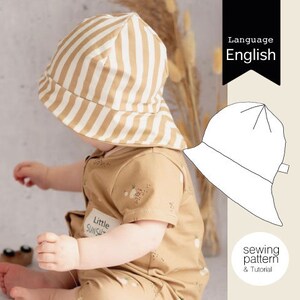 May include: A sewing pattern and tutorial for a striped sun hat for a baby. The pattern is in English. The hat is brown and white striped and has a wide brim.