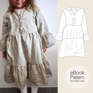 Puede incluir: Un vestido gris de capas con mangas largas y cierre de botones. El vestido tiene un dobladillo con volantes y un dise&ntilde;o simple y cl&aacute;sico. La imagen tambi&eacute;n incluye un dibujo de l&iacute;nea del vestido, etiquetado como "eBook Pattern Schnittmuster".