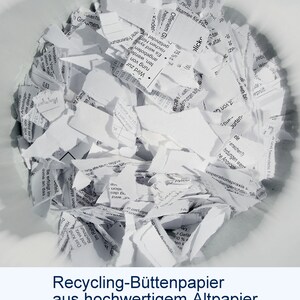 Schwarz-Weiß-Foto einer Schüssel mit Papierschnipseln. Unter dem Foto steht der Text: "Recycling-Büttenpapier aus hochwertigem Altpapier".
