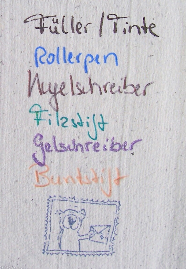 Weißer Büttenpapier-Zettel mit den Schriftproben einzelner Stifte.