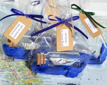 Miniature ships made from old maps in a bottle