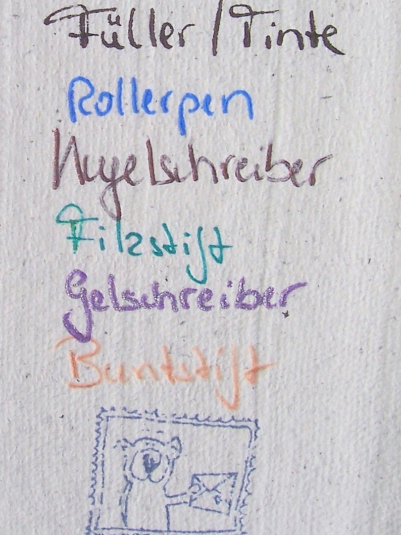 Foto des Schriftprobenzettels. Mit verschiedenen Stiften ist jeweils geschrieben worden (von oben nach unten): "Füller/Tinte", "Rollerpen", "Kugelschreiber", "Filzstift", "Gelschreiber", "Buntstift". Unten ist ein Stempelabdruck zu sehen mit dem Motiv einer quadratischen Briefmarke mit Zackenrand, auf der ein Bär einen Briefumschlag in der ausgestreckten Hand hält.