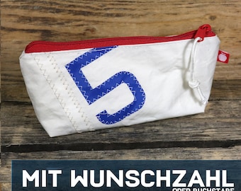 May include: White canvas zippered pouch with a red zipper and a blue number "5" printed on the front. The pouch has a white drawstring and a small red apple logo.  MIT WUNSCHZAHL ODER BUCHSTABE.