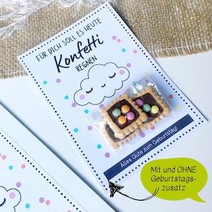 Könnte beinhalten: Eine weiße Karte mit dem Text "Konfetti Regnen" und einer Wolkenillustration, mit bunten Konfetti-Punkten. Zwei quadratische Kekse mit Schokolade und bunten Süßigkeiten befinden sich in einer transparenten Plastiktüte. Die Karte sagt "Alles Gute zum Geburtstag!"