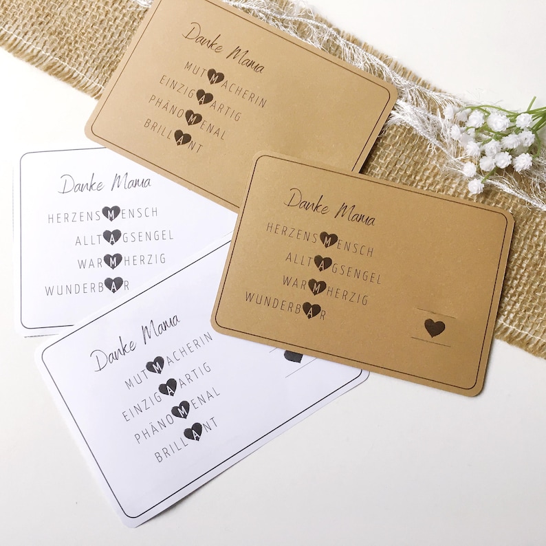 May include: Four brown cards with white text and black hearts. The text on the cards reads "Danke Mama" and lists positive adjectives describing a mother.