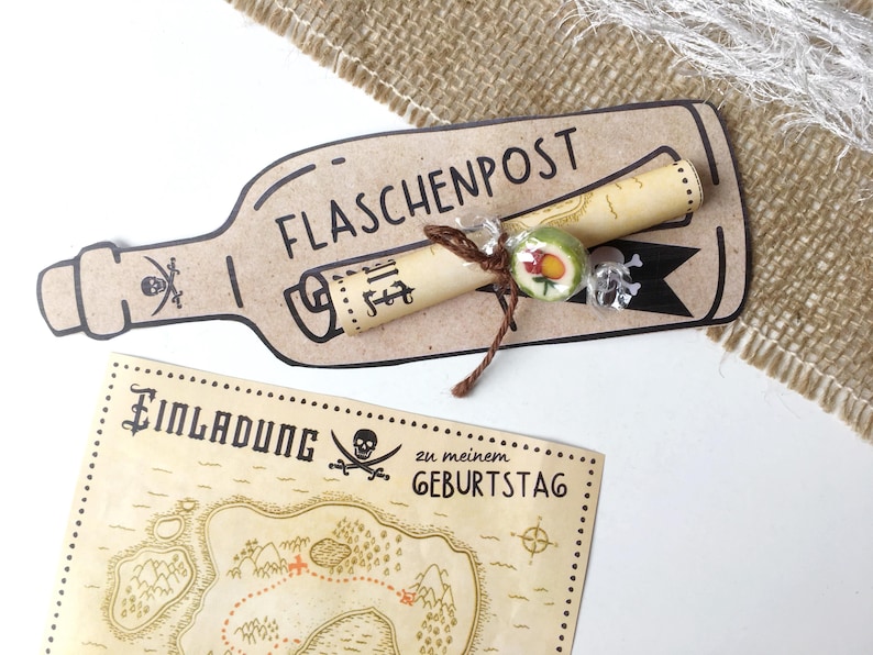 May include: A brown paper bottle with the text "FLASCHENPOST" on it. A rolled up piece of paper with text is tied to the bottle with twine. A green and red candy is tied to the twine. A brown and tan map with the text "Einladung zu meinem Geburtstag" is in the background.